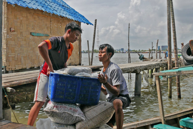 Fishermen haul their catch from the boat.