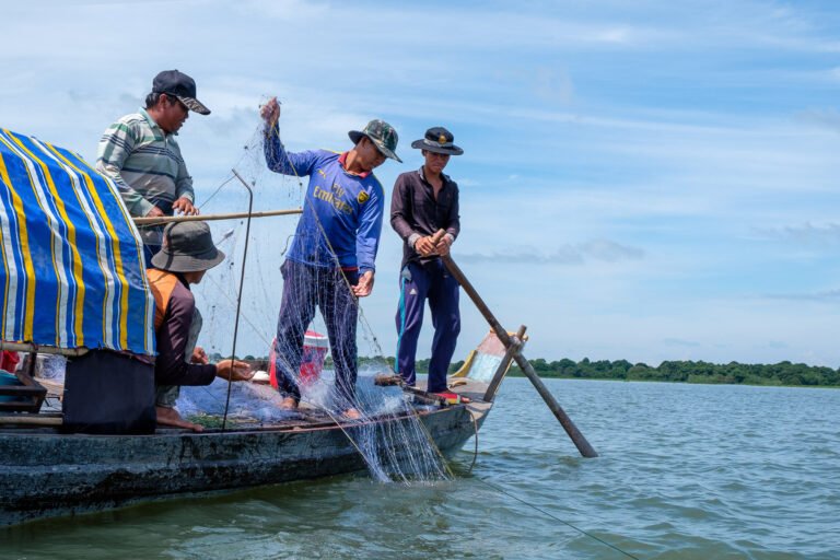 Fishers pull in nets on Tonle Sap Lake in Cambodia