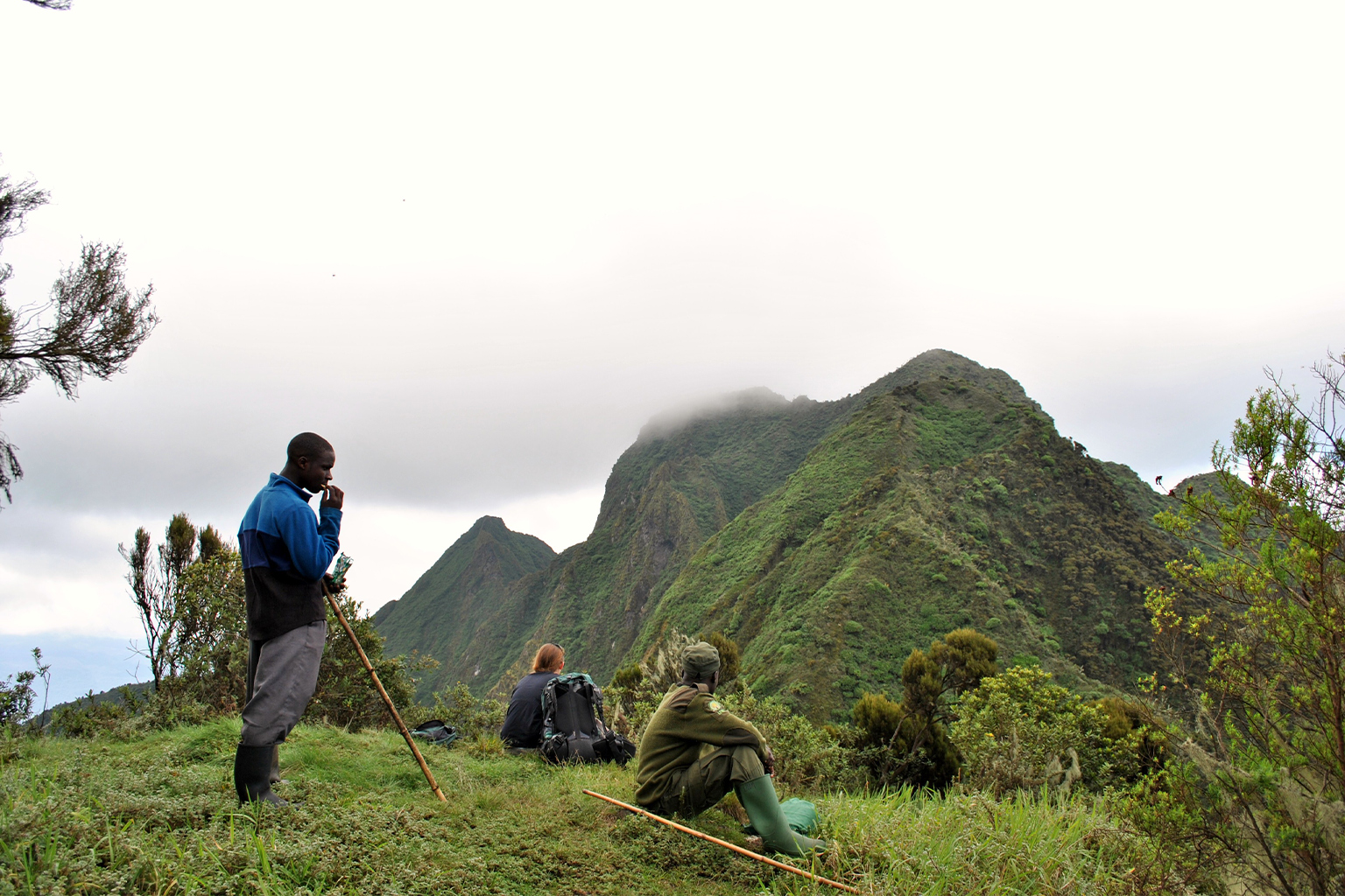 Tourists and guides take a break during a gorilla tourism trek in Mgahinga National Park.